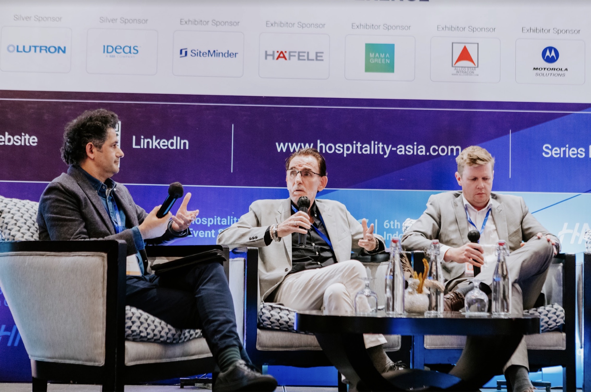 Bert speaking into a microphone during a hospitality panel discussion